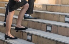 businessman legs walking up the stairs in the city.